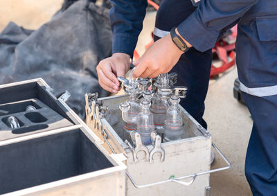 Environment officer connect test tube for sampling air from stack of boiler in factory.