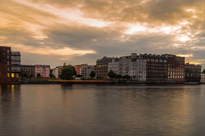 Buildings in city against cloudy sky