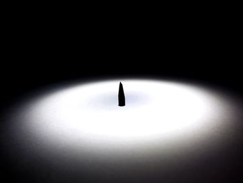 Close-up of illuminated light bulb over black background