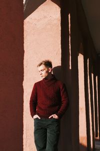 Young man standing against wall