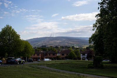 Houses by trees and buildings against sky