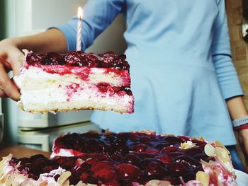 Midsection of woman holding cake