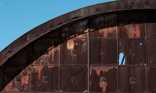 Low angle view of abandoned building against clear blue sky