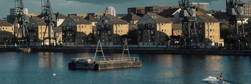 Sailboats in sea by buildings in city