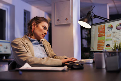 Young man using laptop at desk in office