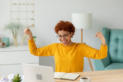 Portrait of smiling woman using digital tablet while sitting in office