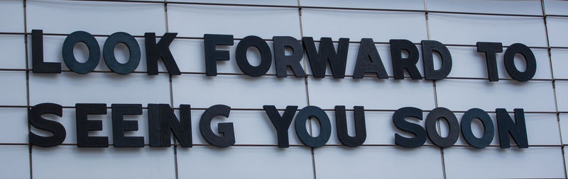 Close-up of text on glass wall