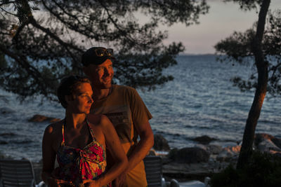 Smiling couple standing at sea