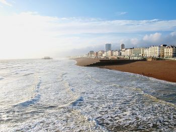 Scenic view of sea by city against sky