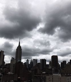 Modern cityscape against cloudy sky