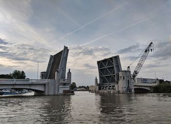 Bridge over river against sky in city