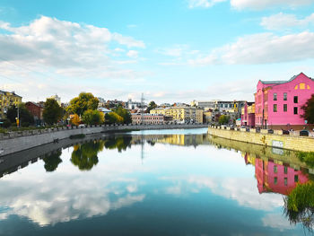 Scenic view of lake by buildings against sky