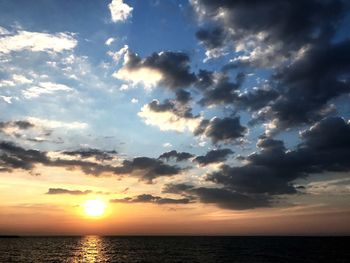 Scenic view of sea against dramatic sky during sunset
