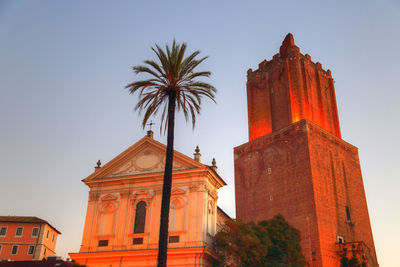 Low angle view of palm trees and buildings against sky