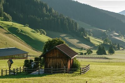 House on field against mountain