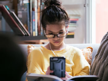 Rear view of girl looking through smart phone