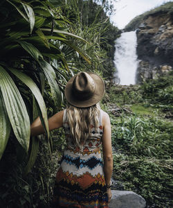 A young woman is exploring a waterfall in ecuador.