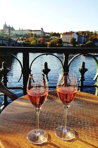 Close-up of beer on table against river during sunset