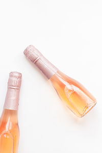 High angle view of bottles on table against white background