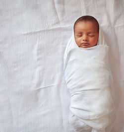 High angle view of baby sleeping on bed