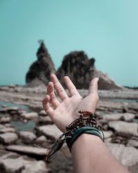 Low section of person hand against clear sky