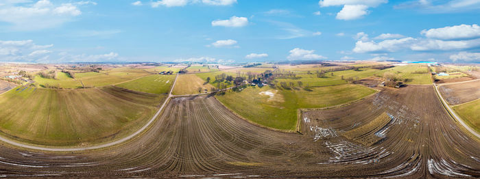 Panoramic view of agricultural field against sky