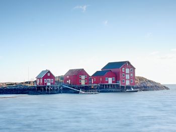 Houses by sea against sky