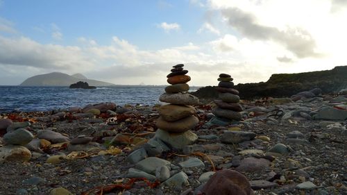 Stack of stones on beach against sky