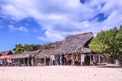 Built structure on beach by house against sky