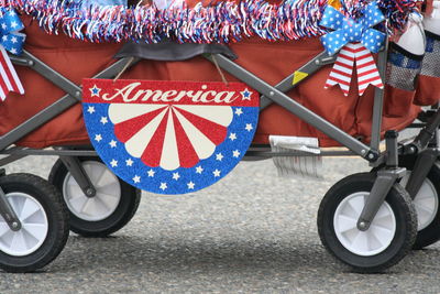 Text on vehicle trailer over street during fourth of july parade