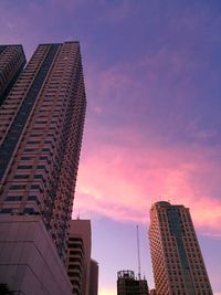 Low angle view of skyscrapers against sky during sunset