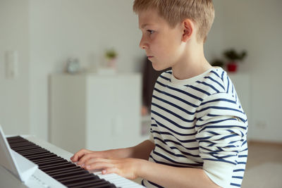 Midsection of boy sitting at home