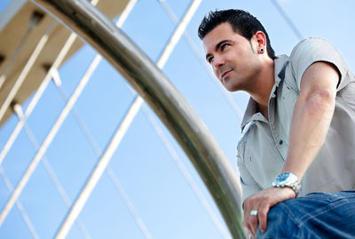 Low angle view of young man standing against sky