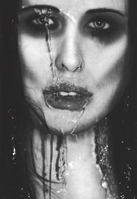 Close-up portrait of woman with water drop