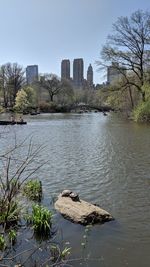 Scenic view of river by buildings against sky