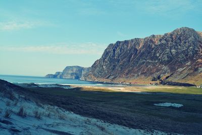 Scenic view of sea and mountains against sky