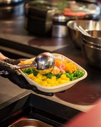 High angle view of hand holding food on table