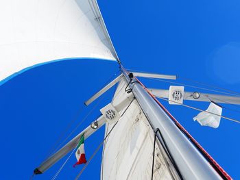 Low angle view of sailboat against clear blue sky