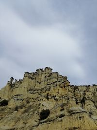 Low angle view of rock formations against sky