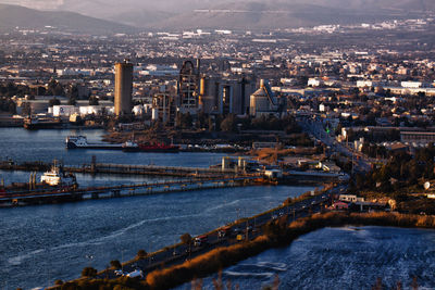 High angle view of river and buildings in city and industrial plant