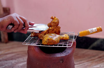 Close-up of man preparing food on barbecue grill