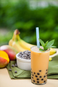 Close-up of juice by fruits on table