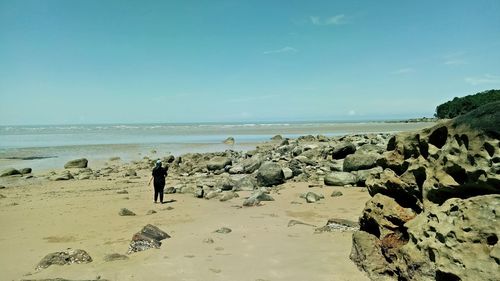 Man standing on beach against clear sky