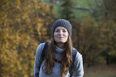 Portrait of beautiful young woman standing in park during autumn