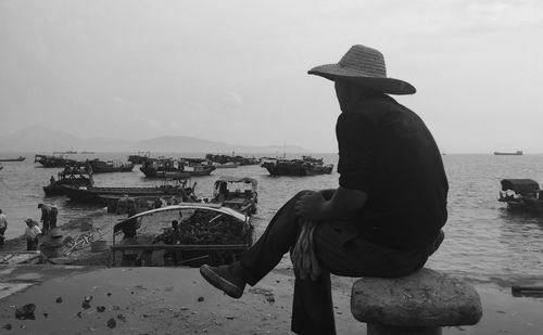 Rear view of man looking at sea against sky