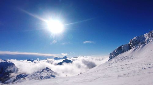 Scenic view of snowcapped mountains against blue sky