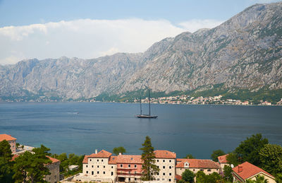 Old-style sailing ship in a bay with coastal houses