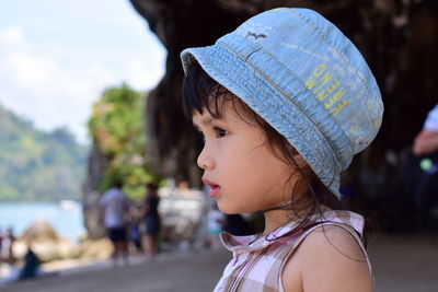 Close-up of girl wearing hat while looking away