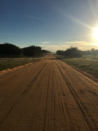 Tire tracks on agricultural field against sky