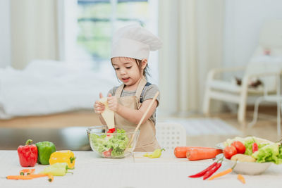 Cute girl preparing food on table